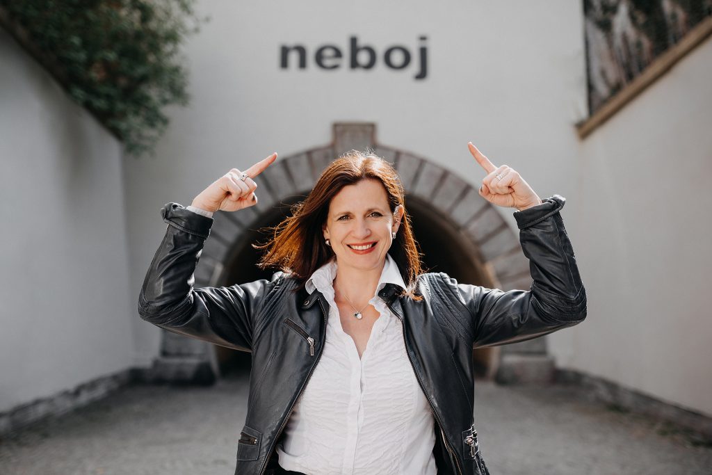 Simona Bodláková s gestem směrem k nápisu „neboj“ na zdi