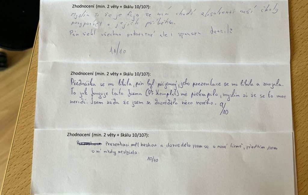 Studenti hodnotí přednášku Jiřího Procházky na ručně psaných formulářích se zpětnou vazbou.